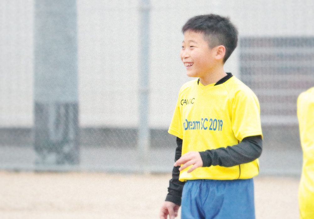 サッカースクールを笑顔で楽しむ子供たち